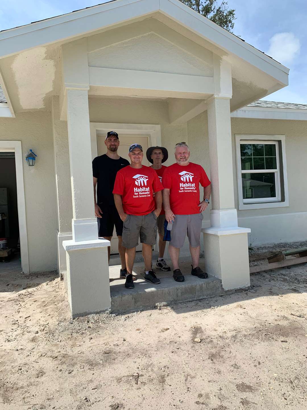 a group of men standing in front of a house